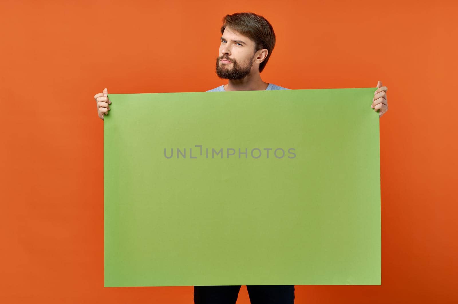 emotional man holding a green banner design studio lifestyle. High quality photo