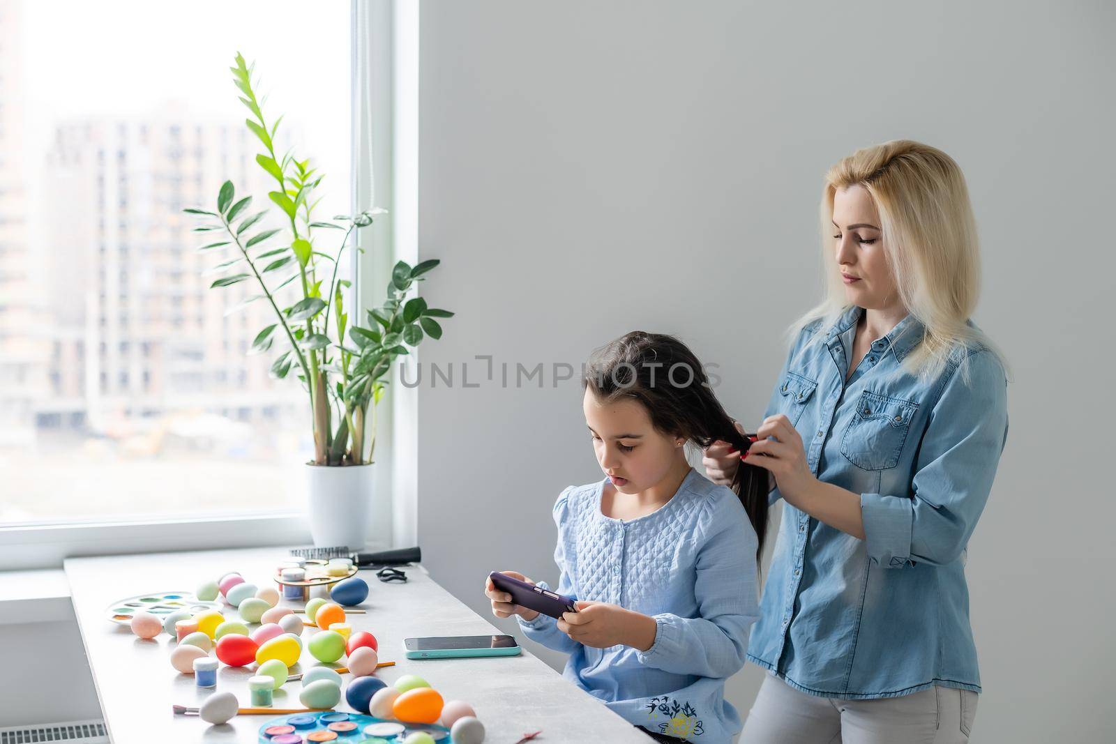Happy family preparing for Easter. mom combing daughter.