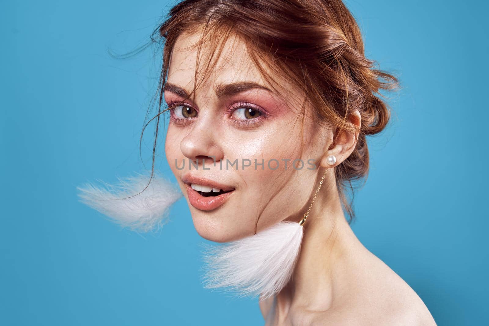 woman with bare shoulders bright makeup decoration fashion blue background. High quality photo