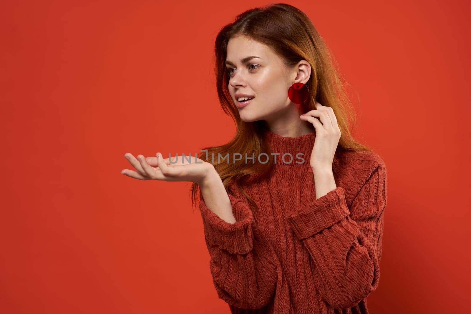 woman in red sweater earrings jewelry red background gesture with hands by SHOTPRIME