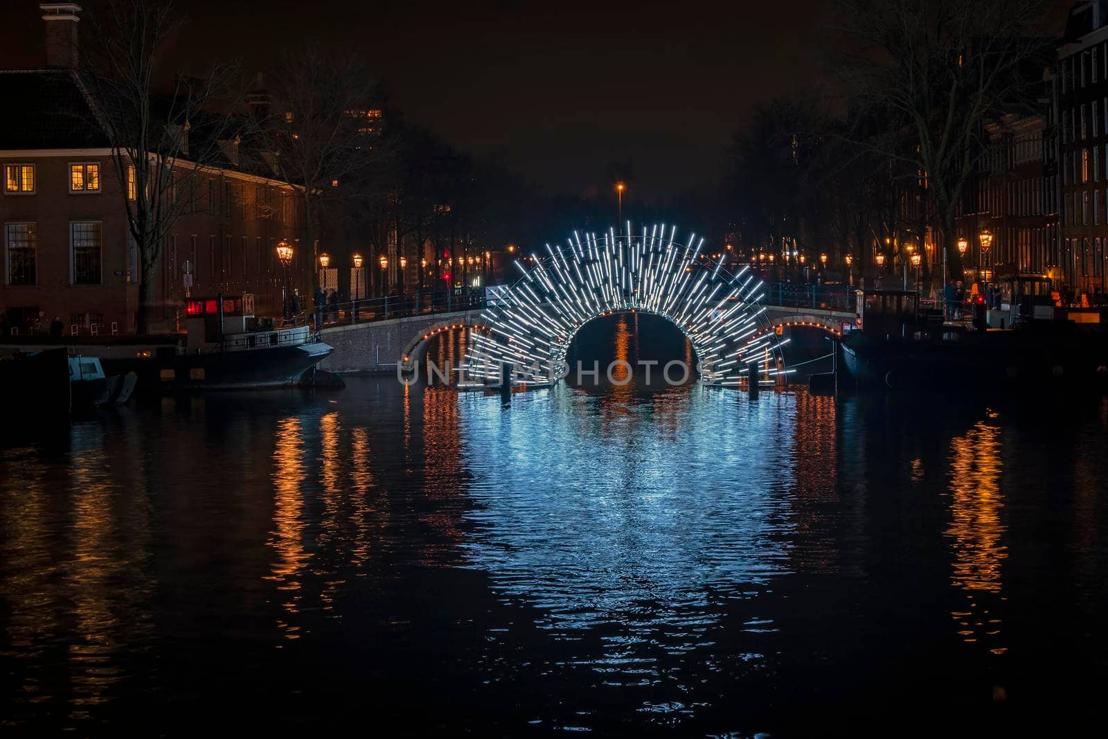 Illuminated bridge in Amsterdam at the Amstel in the Netherlands at night