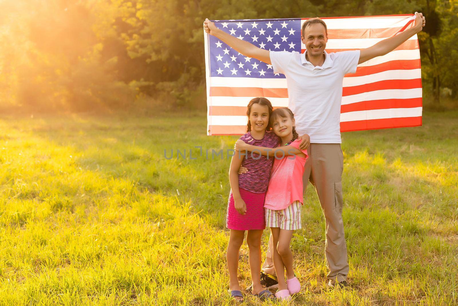 Happy family with the American flag in a wheat field at sunset. Independence Day, 4th of July. by Andelov13