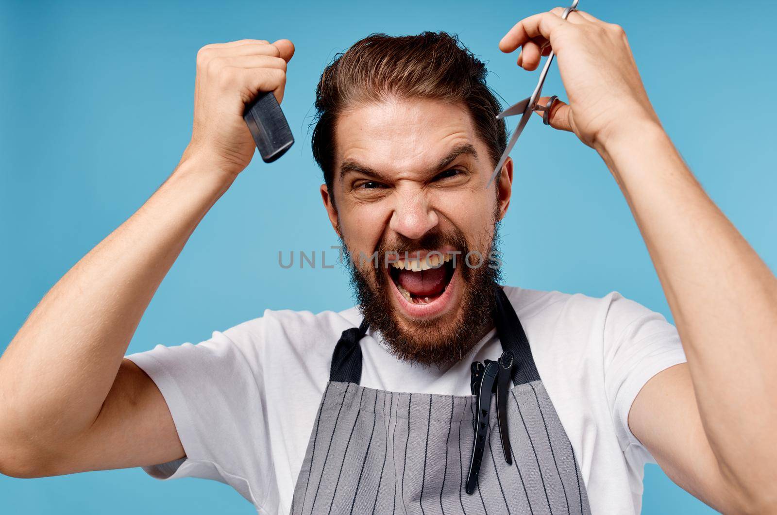 emotional male hairdresser with scissors and comb model beard gray apron cropped view by SHOTPRIME