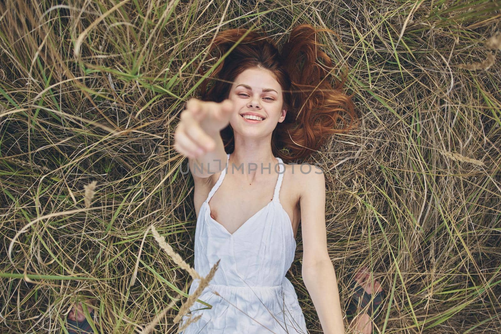 cheerful woman lies on straw in a field summer vacation. High quality photo