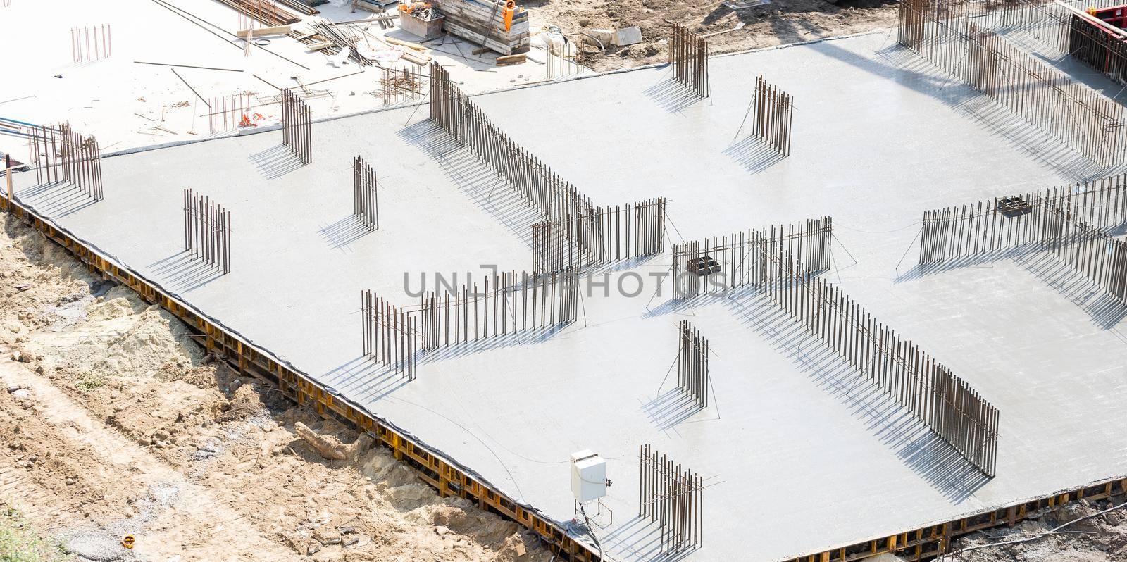 Closeup of house foundation made from concrete shuttering blocks filled with mortar and reinforcement bars.