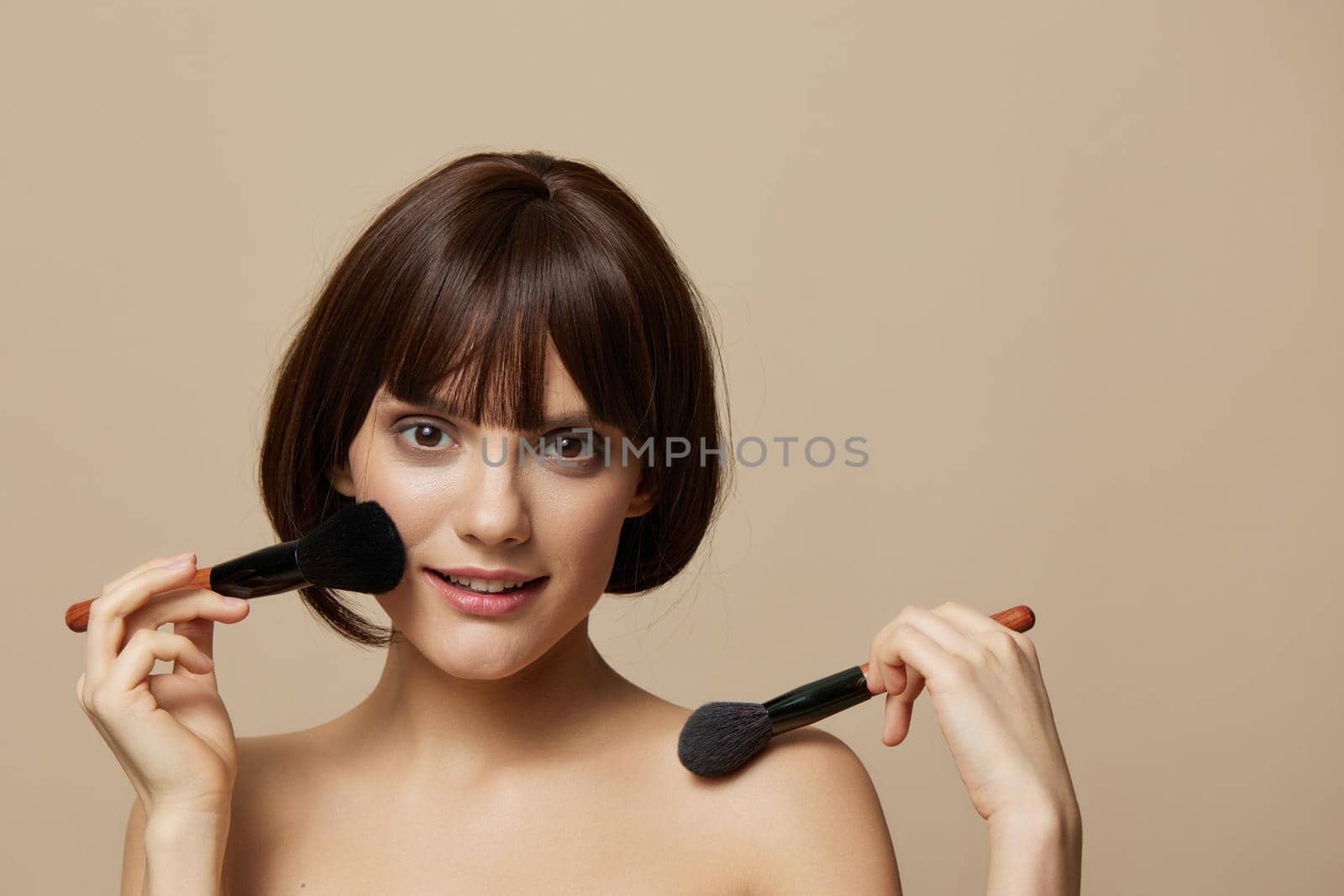 portrait woman makeup brushes near the face bare shoulders isolated background by SHOTPRIME