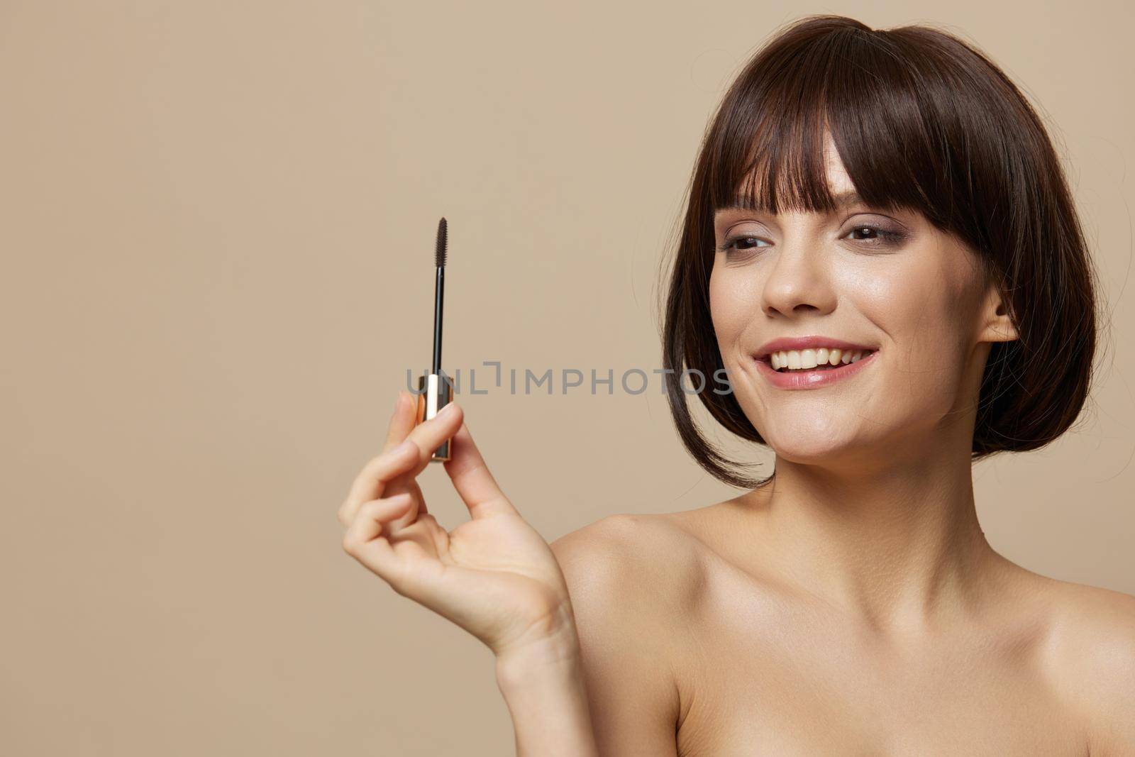 young woman smile mascara charm short haircut beige background. High quality photo