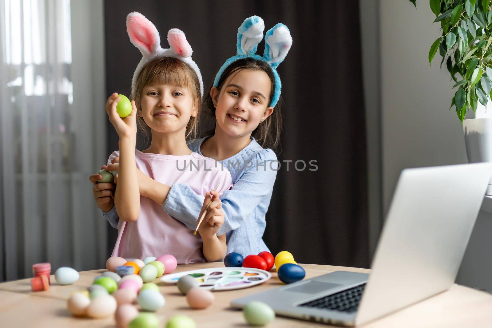 little girls for easter paint eggs, record lessons on web camera with laptop.