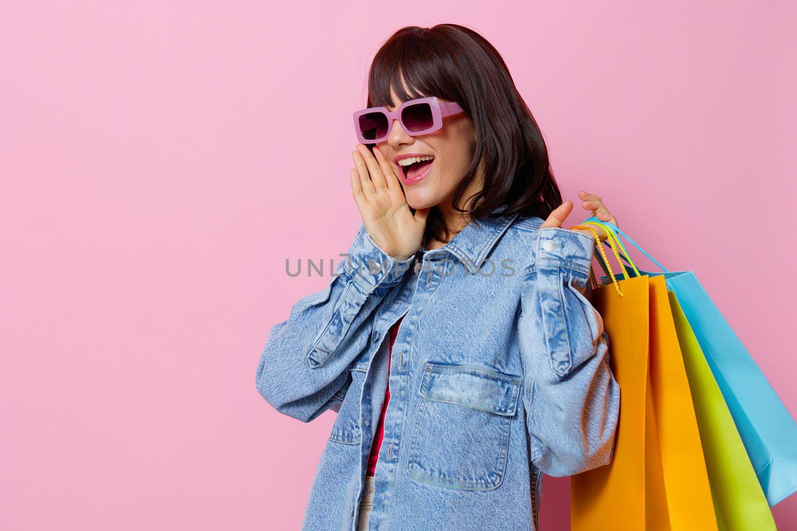 beautiful woman holding colorful bags shopping isolated background by SHOTPRIME