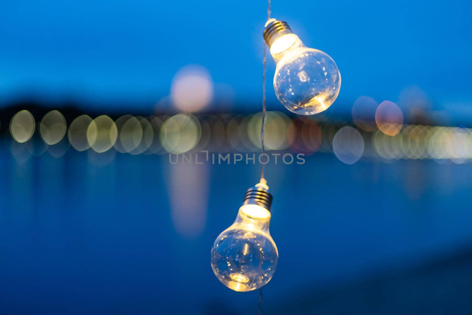 Hanging light bulbs on a background of water.