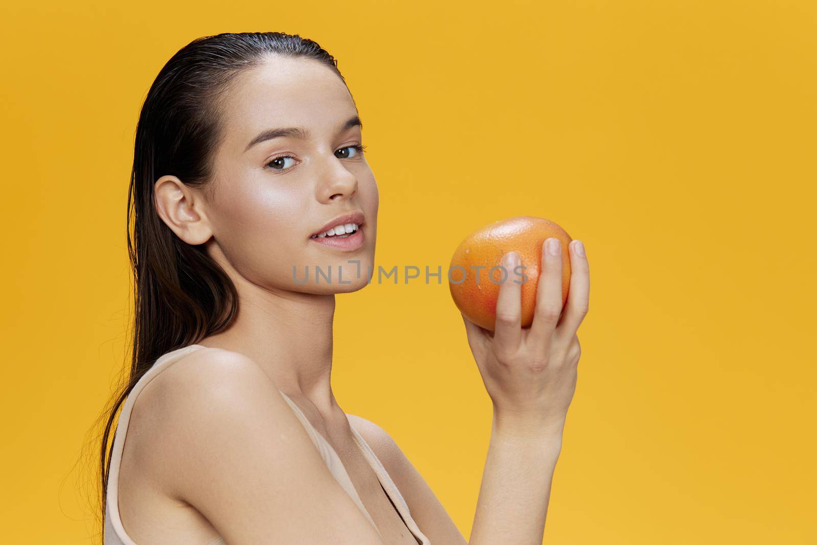 portrait woman grapefruit in hands posing clean skin yellow background by SHOTPRIME