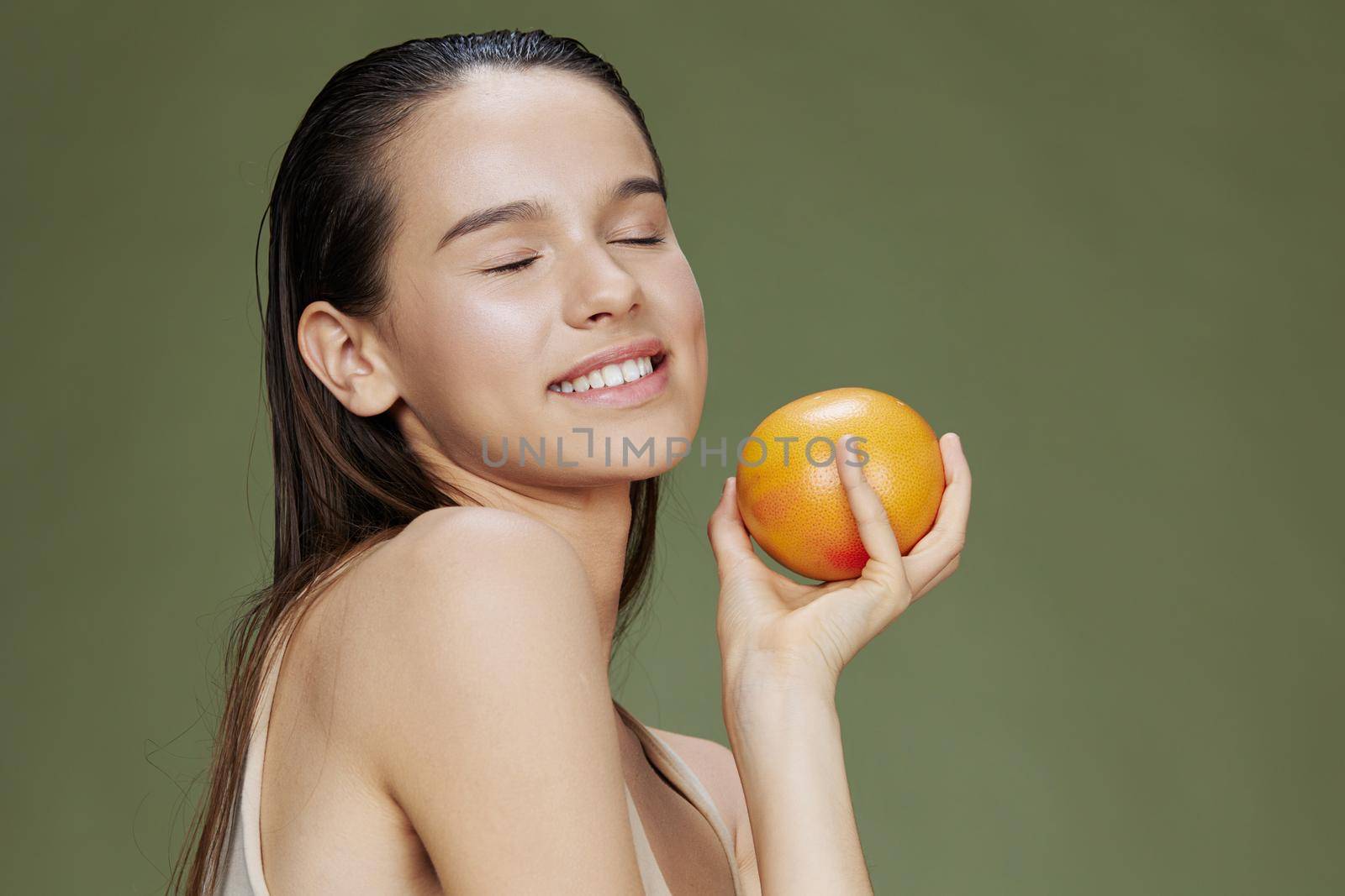 beautiful woman grapefruit in hands posing clean skin isolated background. High quality photo