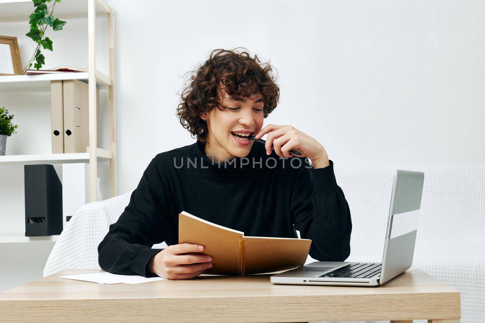 teenager sitting at the table in a black sweater lessons Lifestyle technology. High quality photo