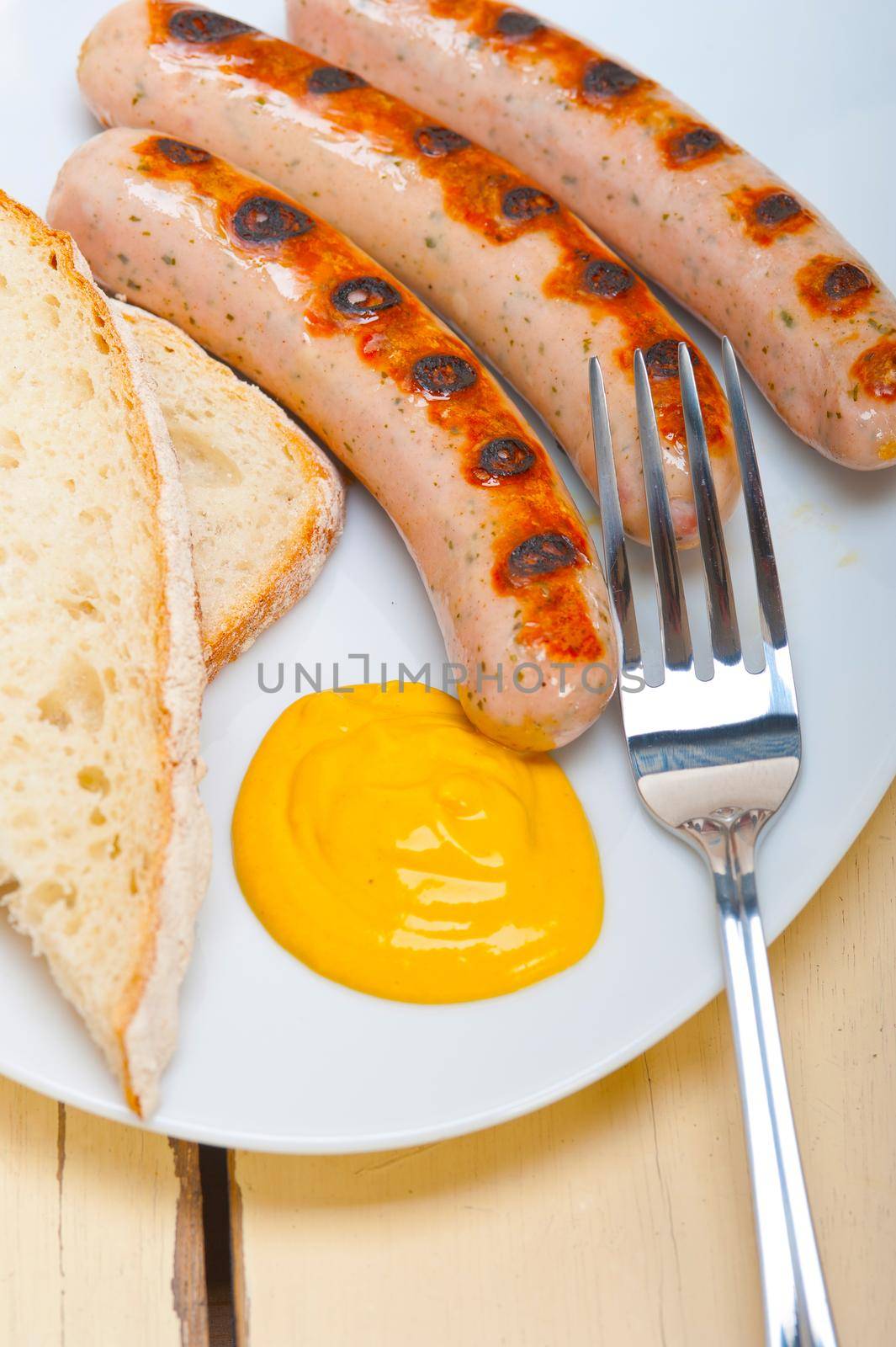 traditional fresh German wurstel sausages grilled with yellow mustard 