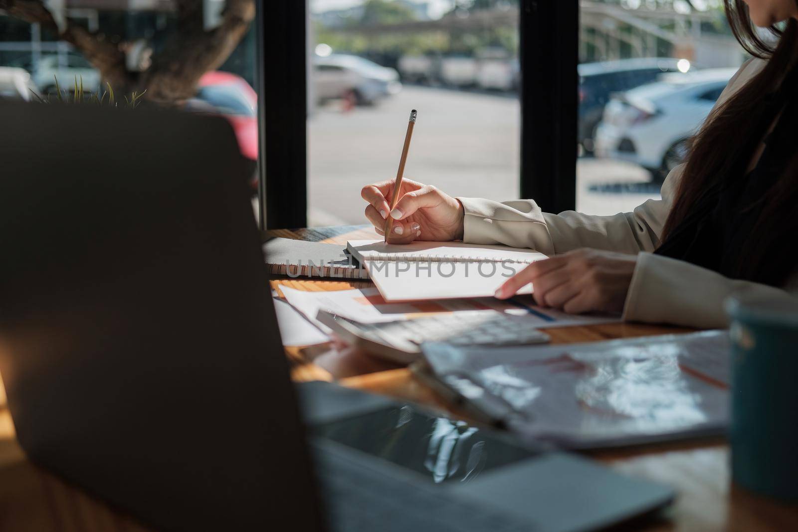 Woman hand taking notes on the notepad. Handwriting. Creative writing. business working for financial accounting calculation at offlice