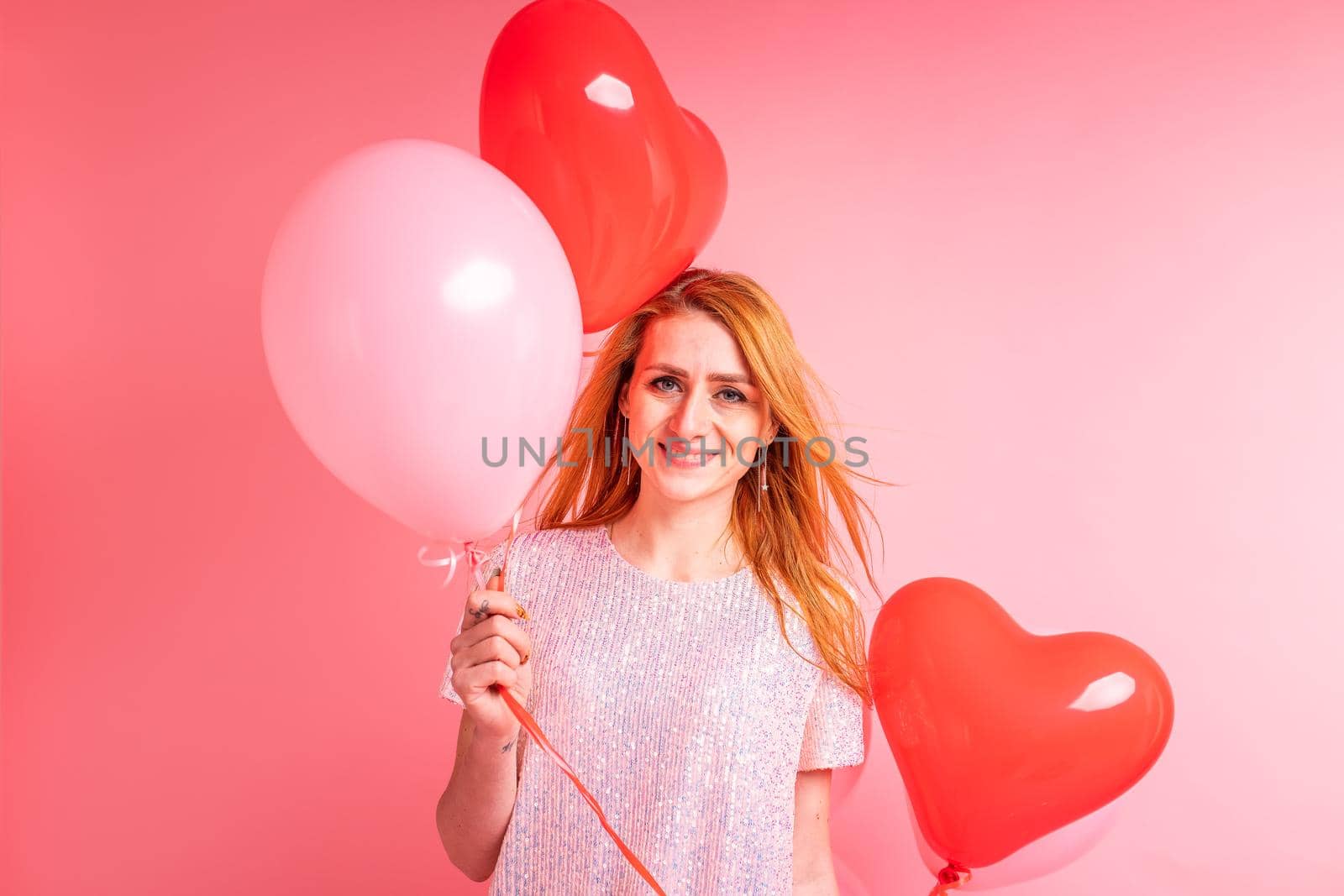 Beautiful redhead girl with red heart baloon posing. Happy Valentine's Day concept by Len44ik