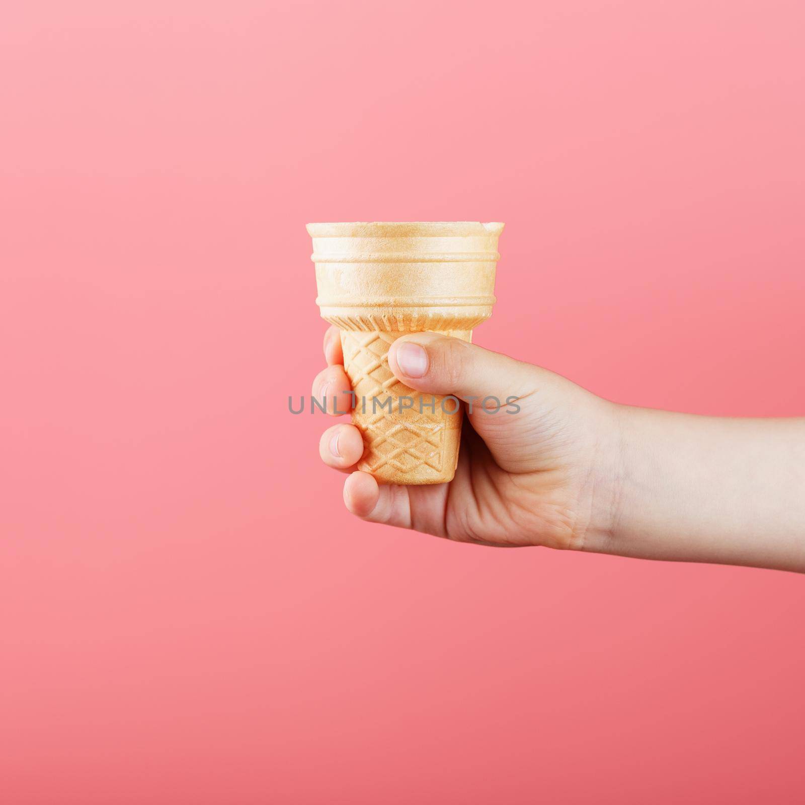 Waffle ice Cream Cup in a child's hand on a pink background. by AlexGrec