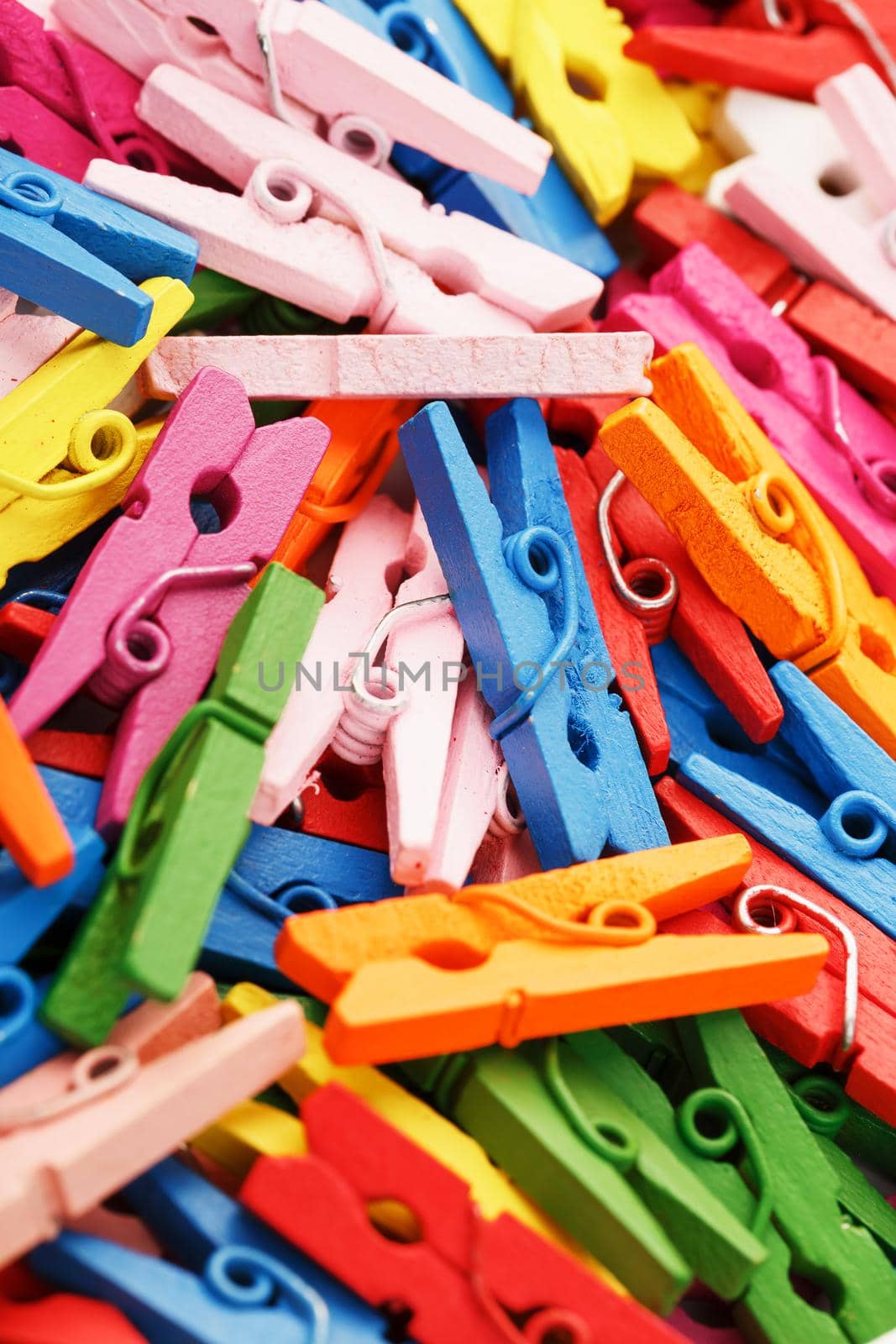 Multi-colored wooden clothespins as a full-screen texture and background. Decorative clothespins for creativity. The view from the top