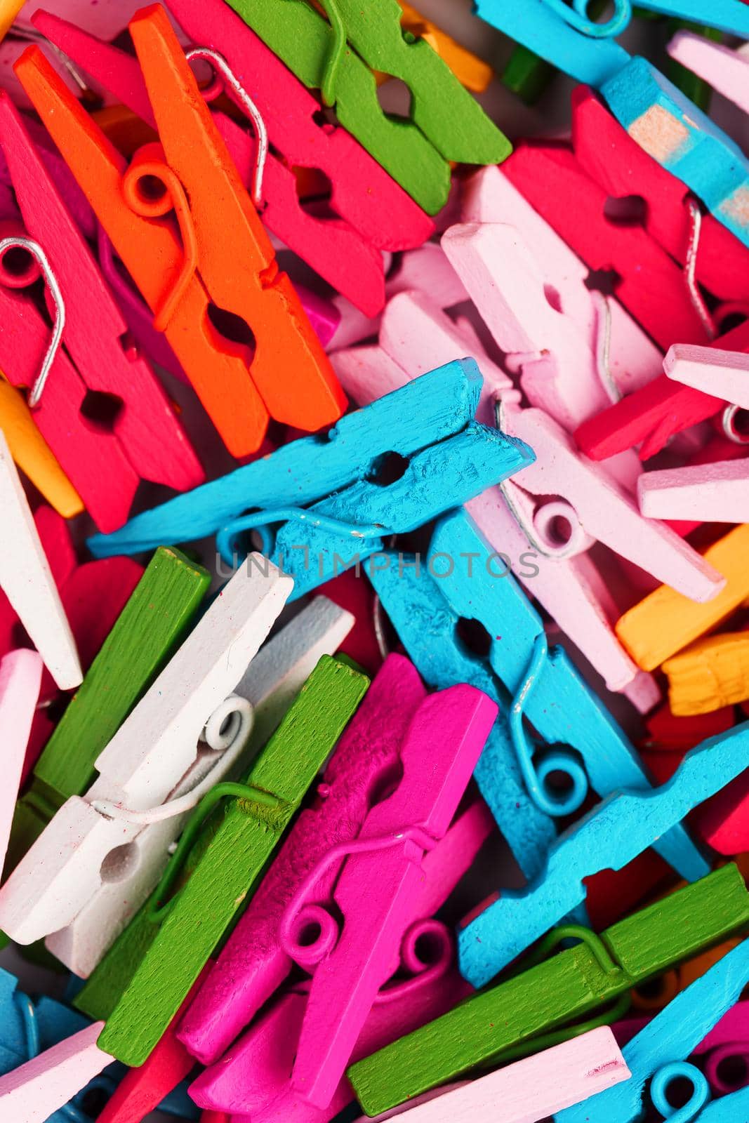 Small Clothespins of different colors close-up as a texture and background in full screen. Decorative clothespins for creativity.