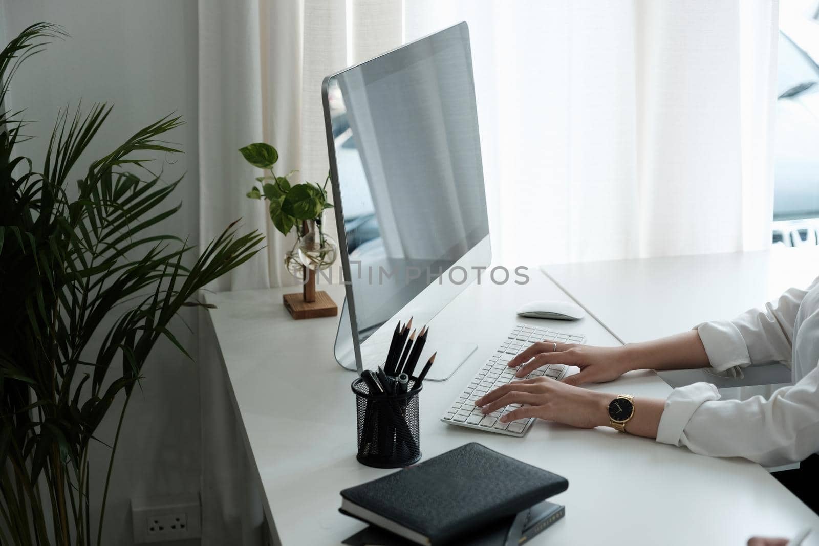 Close-up of woman hands typing on computer keyboard indoors. Businessman working in office or student browsing information.
