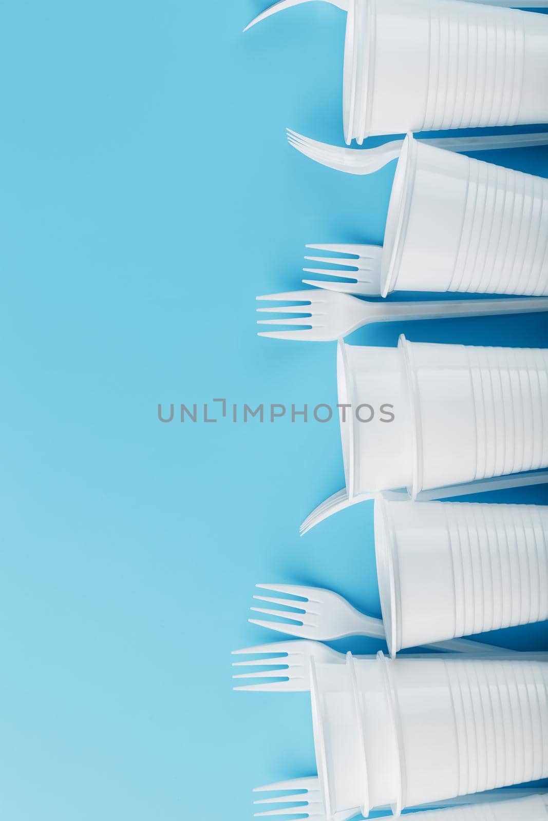 Dishes made of white plastic on a blue background. Free space. The view from the top