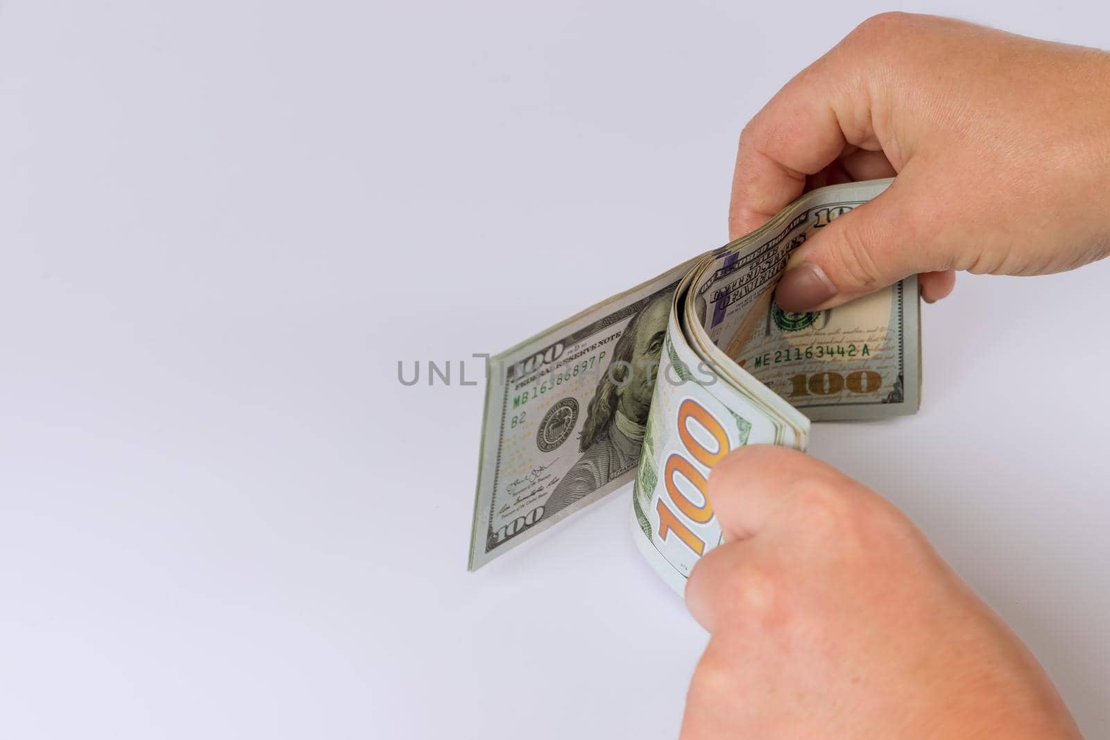 Counting one hundred US dollar banknotes the white background by ungvar