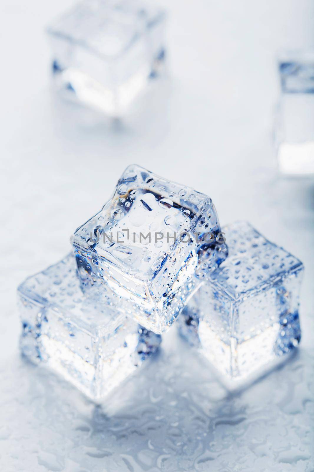 Ice with meltwater drops close-up on a white background. Ice cube