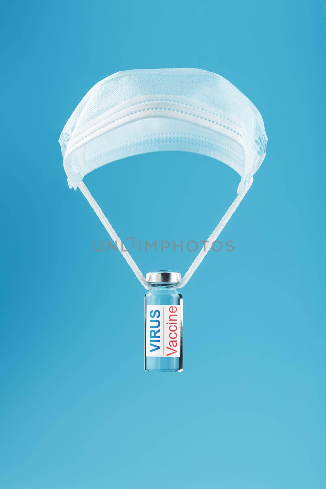 Ampoule and syringe with the vaccine against the Virus against diseases on a blue background. Free space on the ampoule label for text.