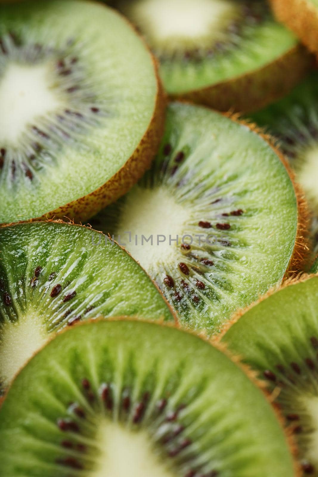 Kiwi fruit cut into slices, in full screen as a background. The concept of healthy and delicious food