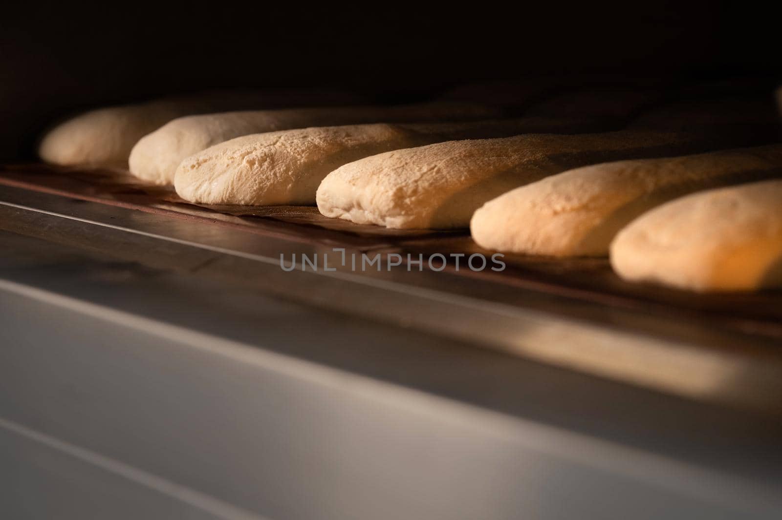 Close-up Batch of fresh buns of artisan bread baked in an oven in cooking and eating concept by yanik88