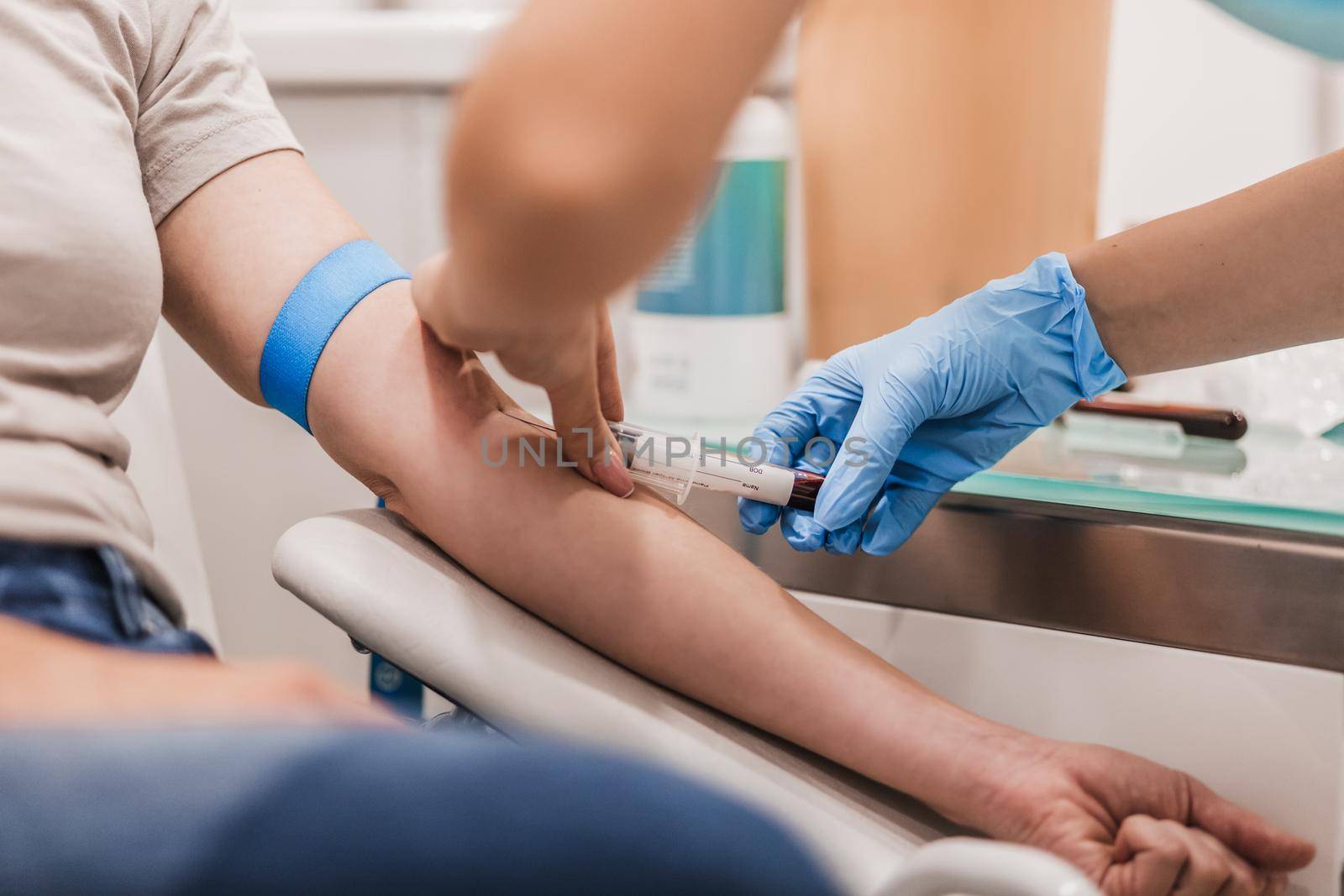 Close-up Of Doctor Taking Blood Sample From Patient's Arm in Hospital for Medical Testing. by kasto