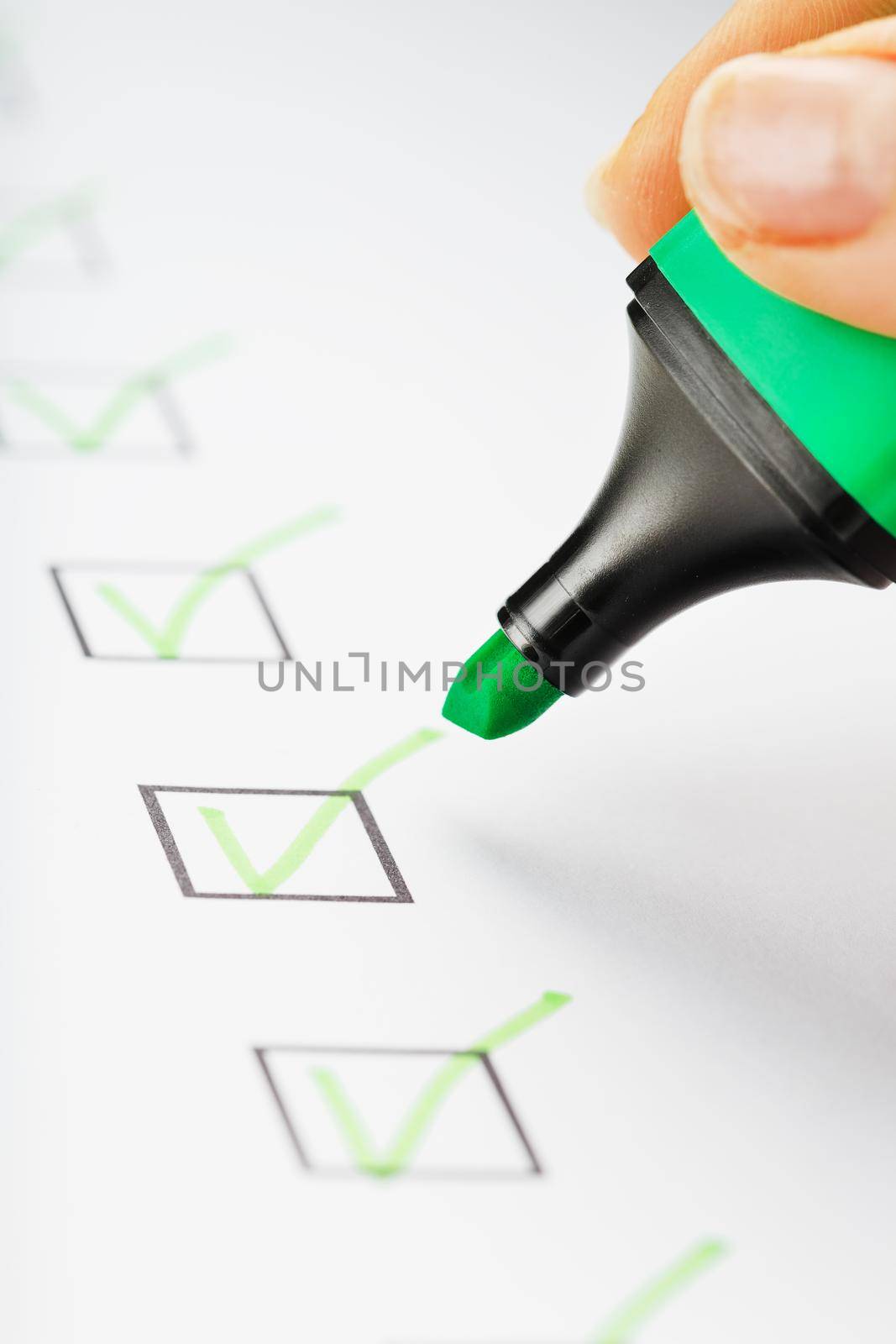 Green marker with markers on the checklist sheet. Checklist completed task concept.