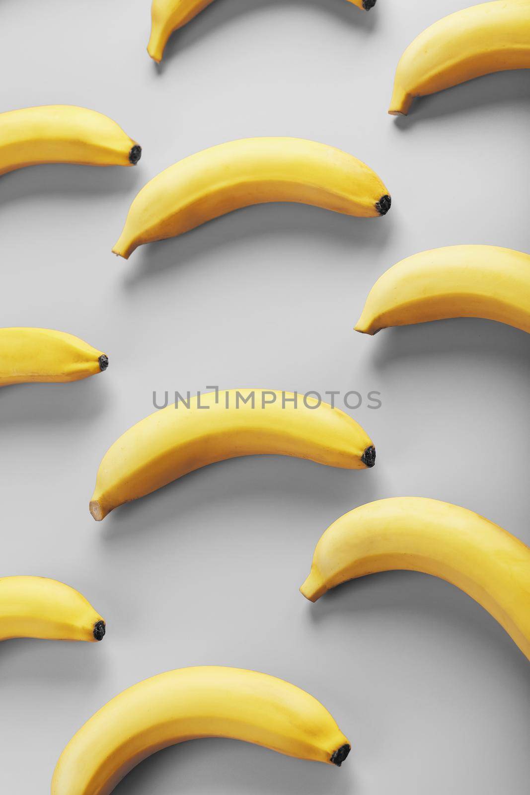 Bright pattern of yellow bananas on a gray background fashionable colors of 2021 by AlexGrec