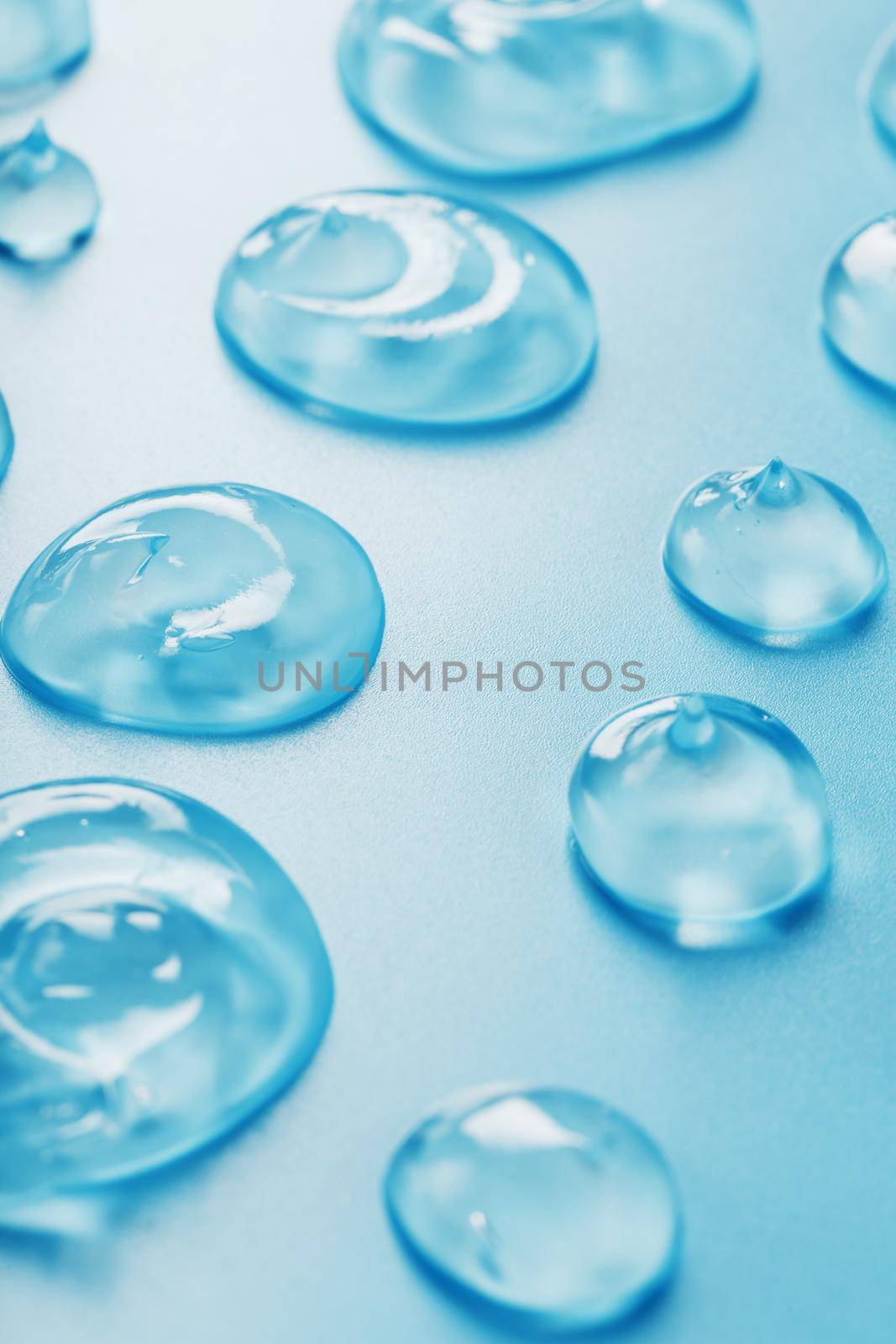 Drops of Gel with hyaluronic acid in the form of a smear of glossy texture on a blue background. Antibacterial cosmetics