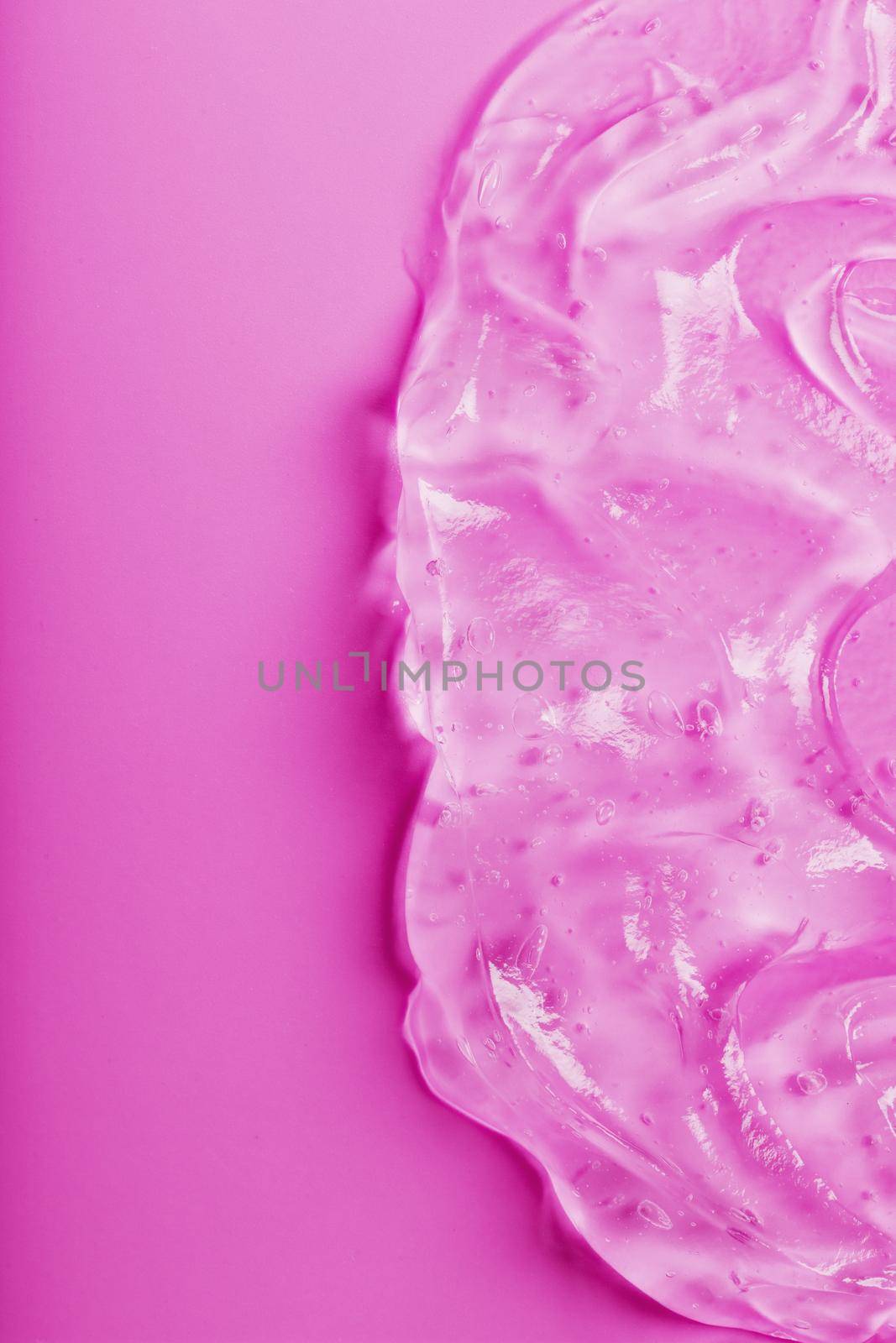 Transparent liquid gel on a pink background with free space. Antiseptic, cosmetic gel