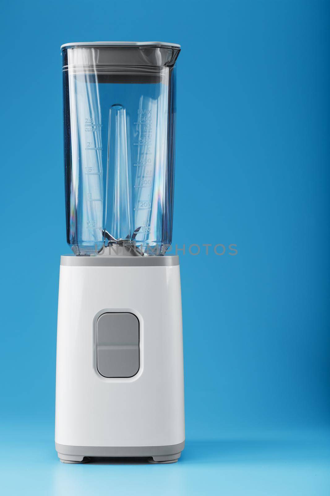 Electric blender with an empty cup on a blue background. Free space, minimalistic concept