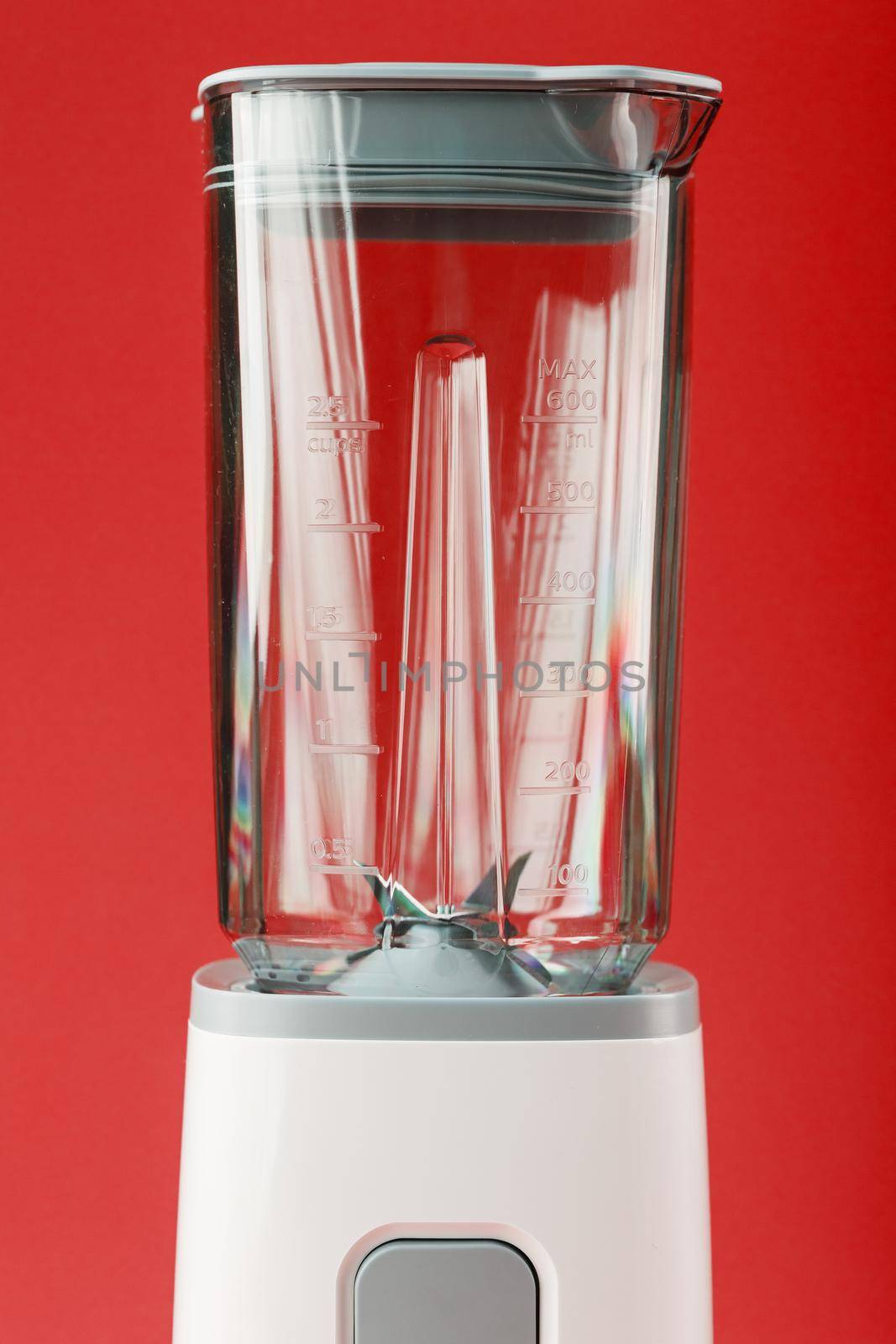 Electric blender with an empty cup on a red background. Free space, minimalistic concept