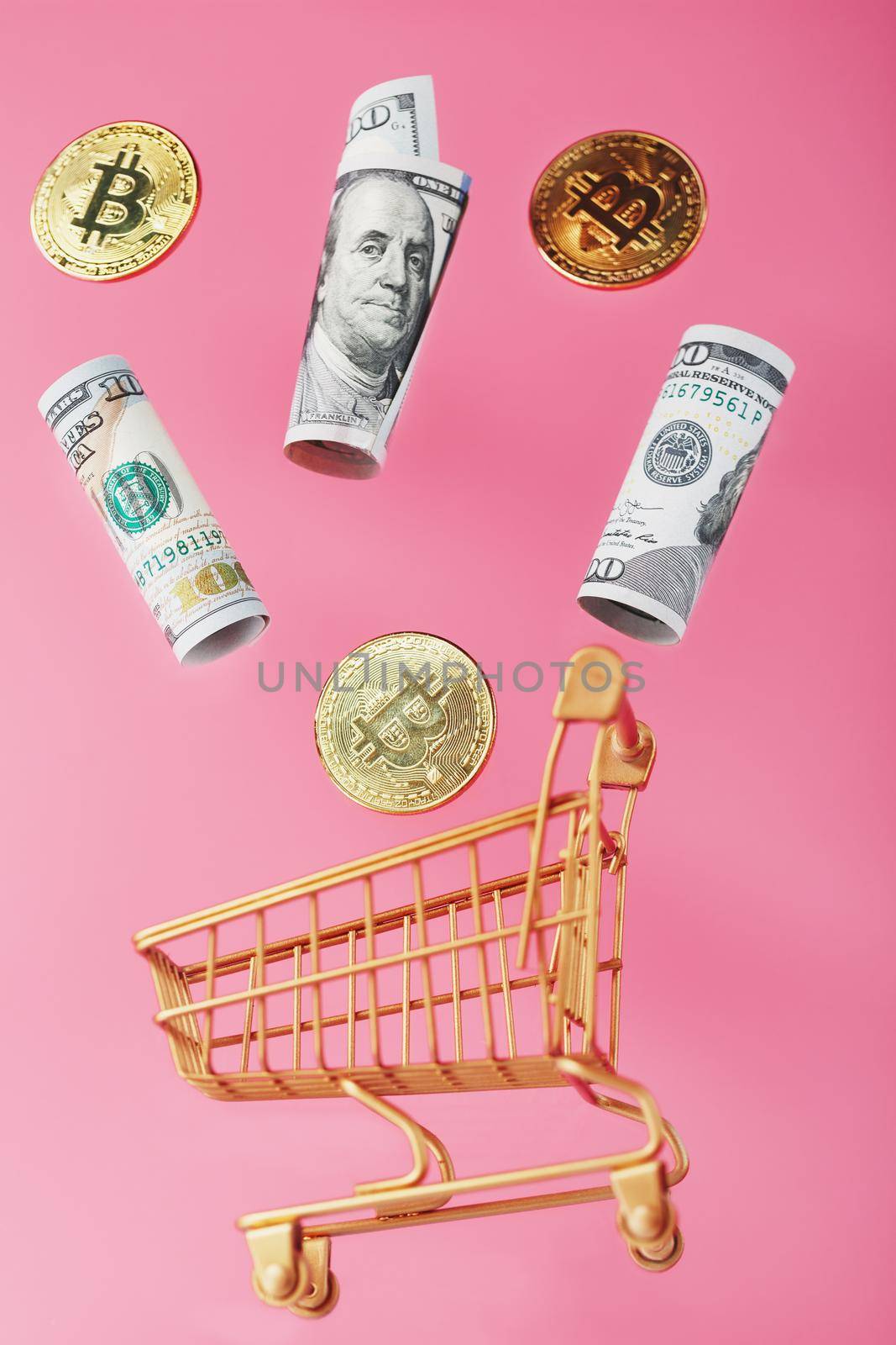 Dollar bills and itkon coins flew out of the Golden Basket on a pink background. Concept businesses, finance, trading, or stock exchange investments