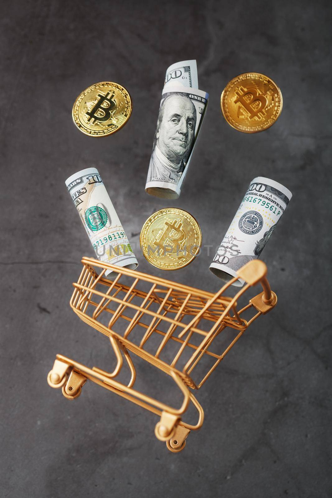 Dollar bills and itkon coins flew out of the Golden Basket on a dark background. Concept businesses, finance, trading, or stock exchange investments