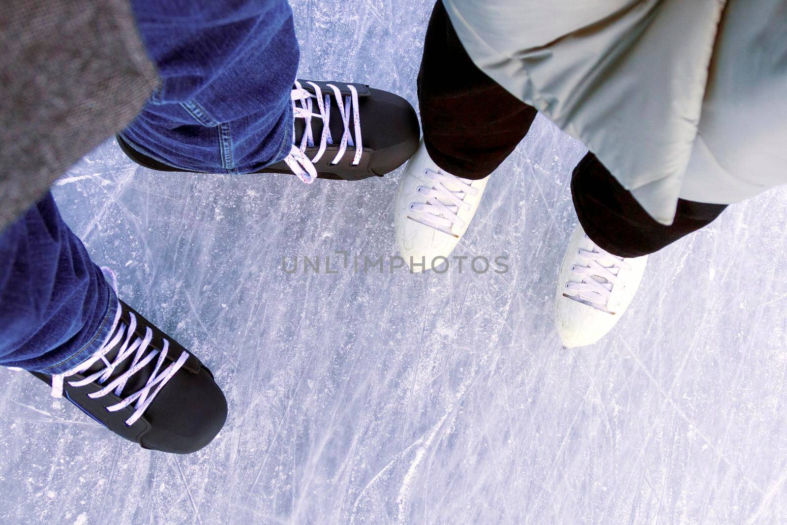 Woman and man together ice skating. Winter activities and fun on the ice rink. Ice and feet