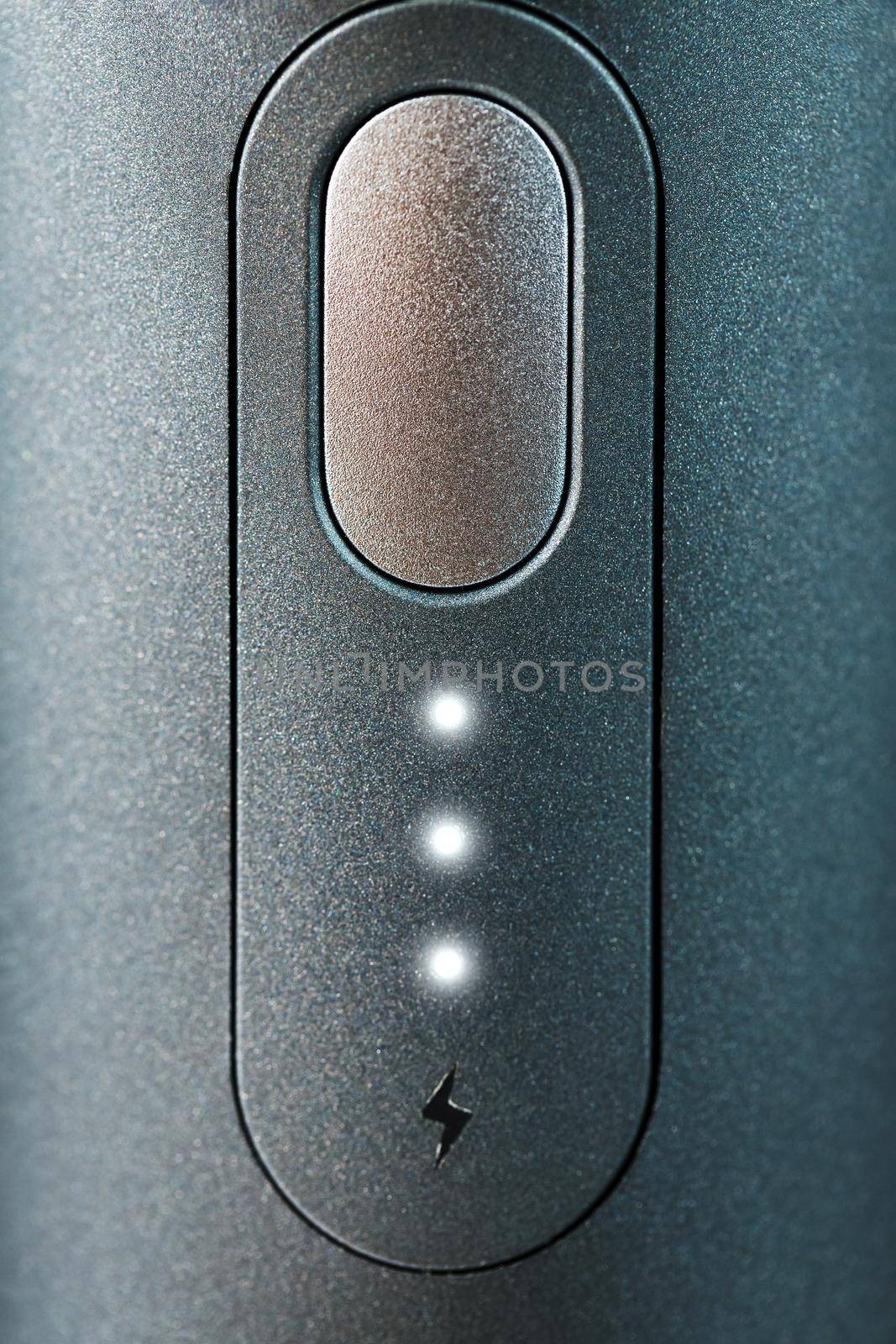 Button with led charging indication close-up. Control panel of the device.