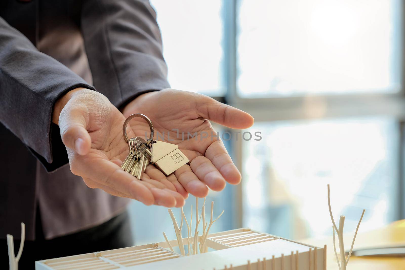 Real estate agent handing over house keys with approved mortgage application form and offer handshake.