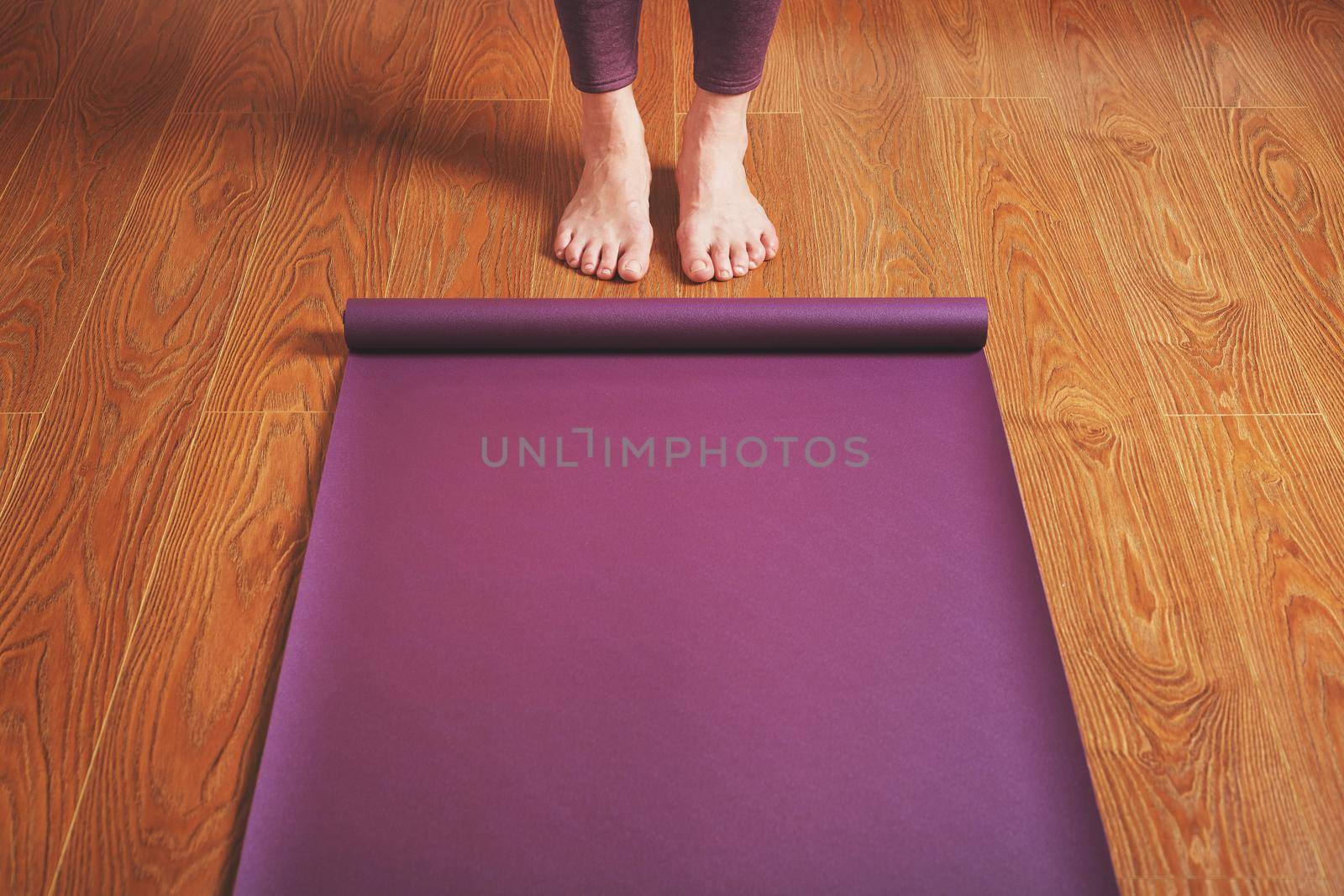 Legs and hands of a woman on a yoga mat practicing asanas. A healthy lifestyle at home in isolation.