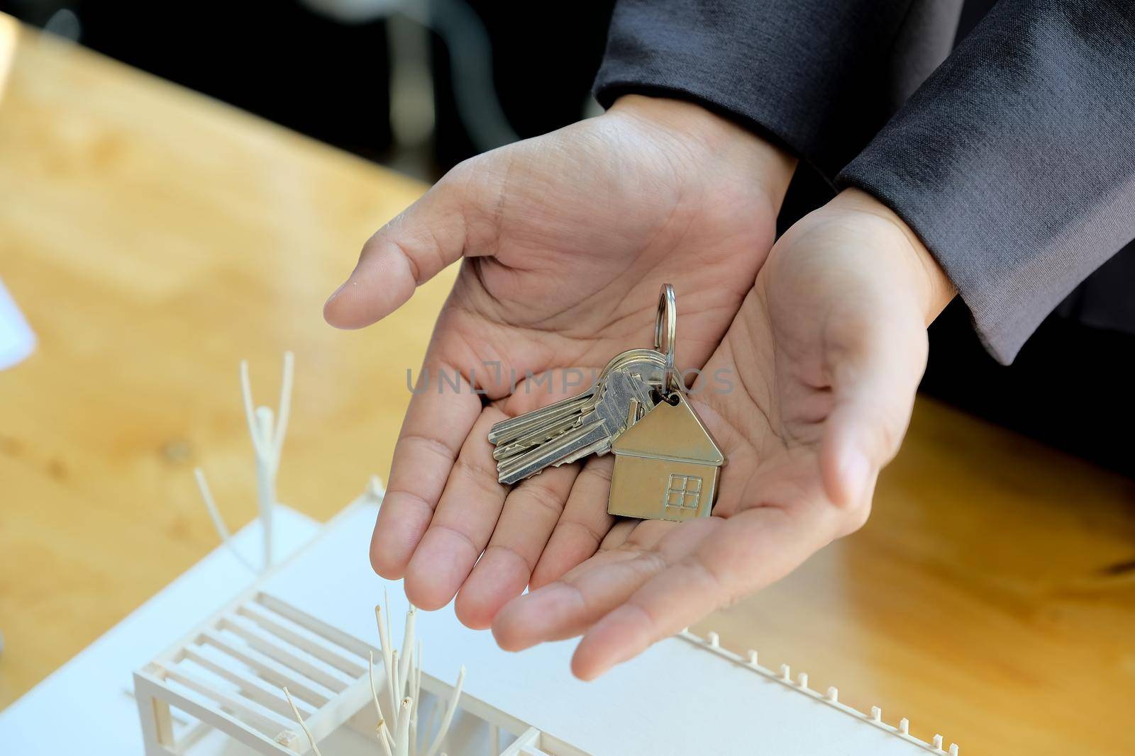 Real estate agent handing over house keys with approved mortgage application form and offer handshake.