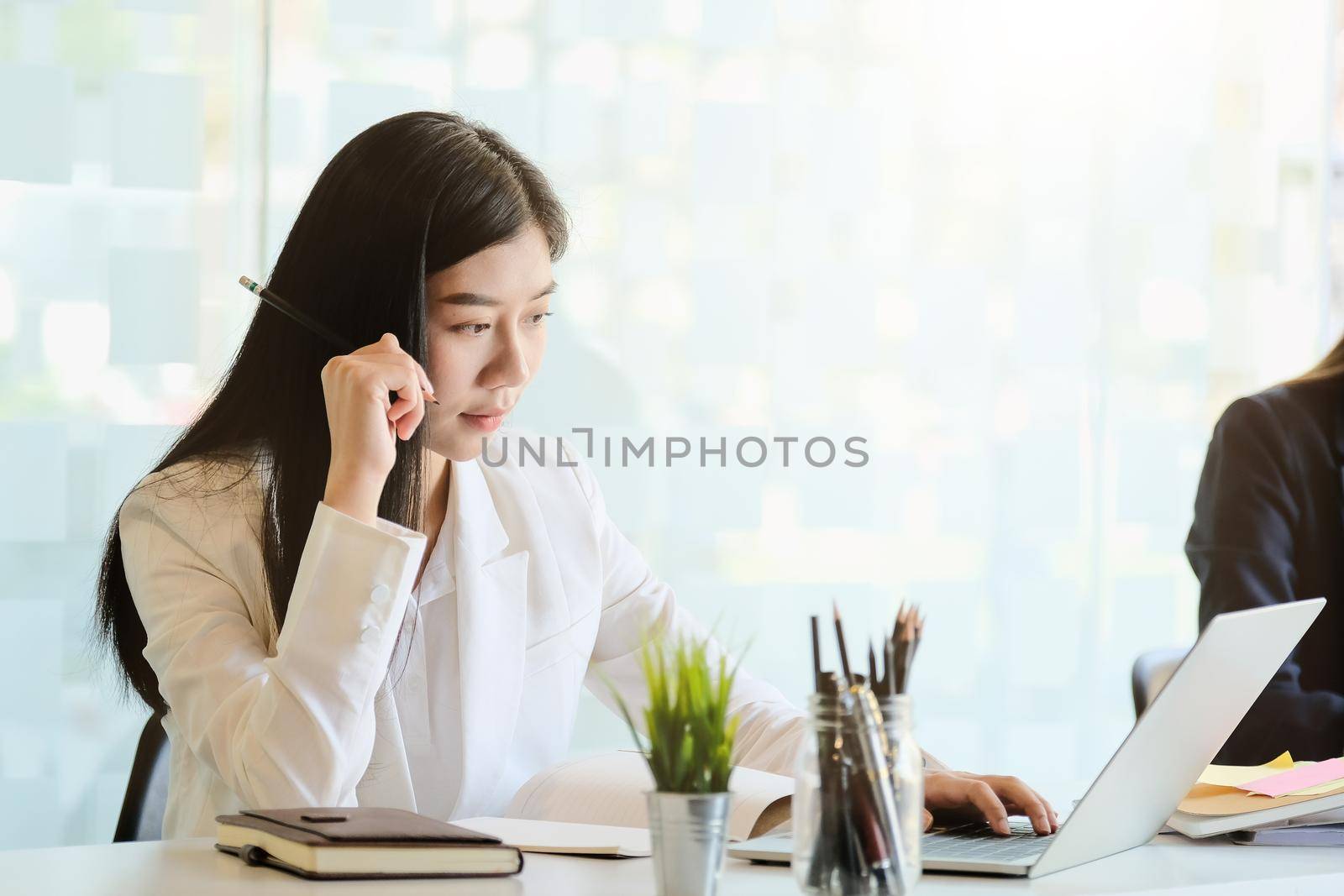Young business woman working in office with laptop computer and financial documents.
