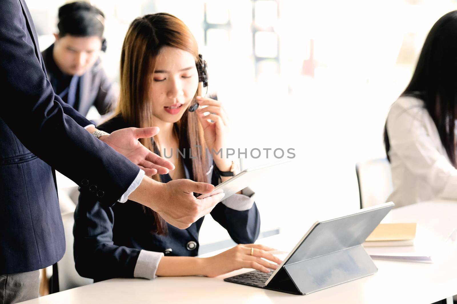Businessman supervisor training work to businsswoman in call center office by nateemee