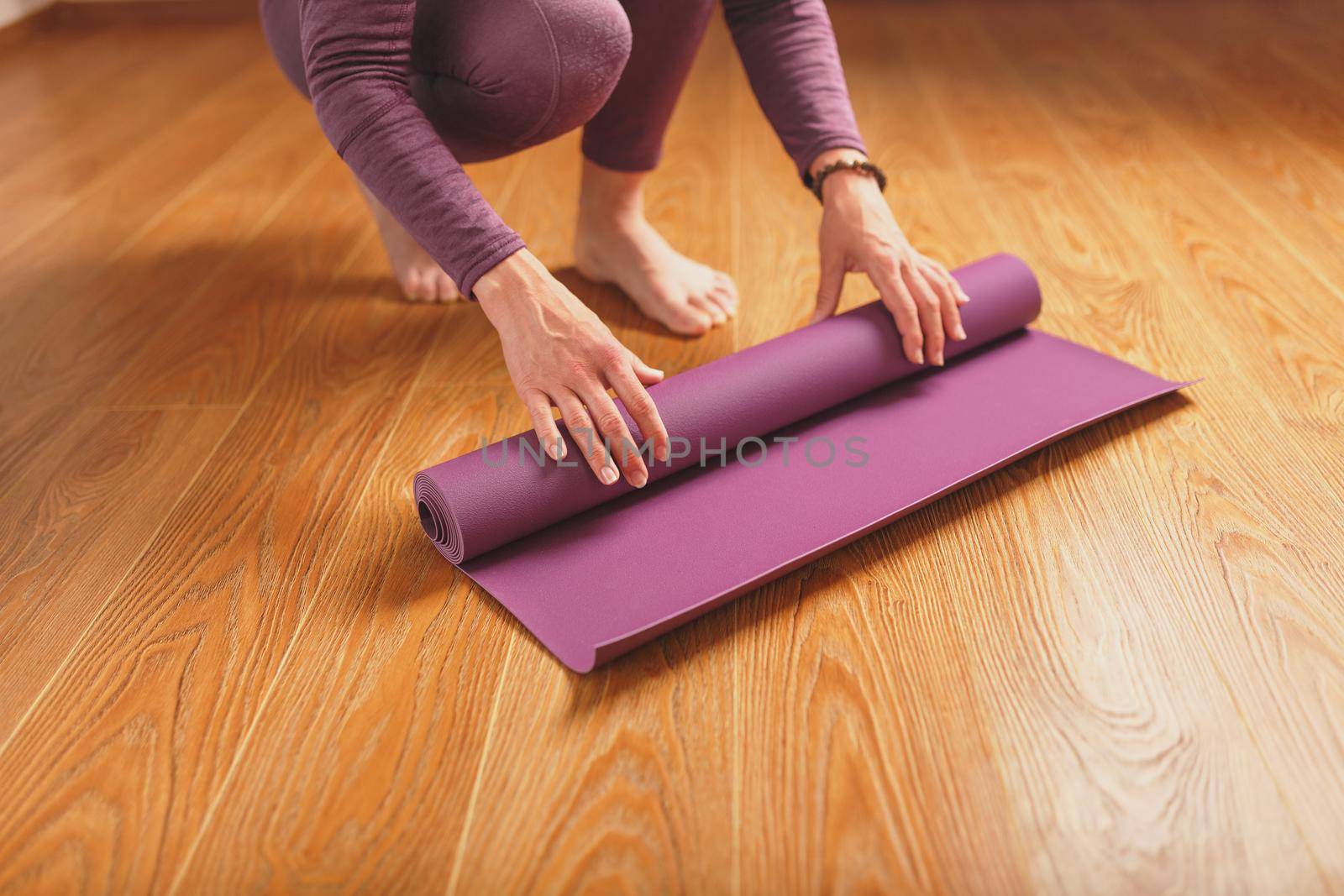 Legs and hands of a woman on a yoga mat practicing asanas. A healthy lifestyle at home in isolation.