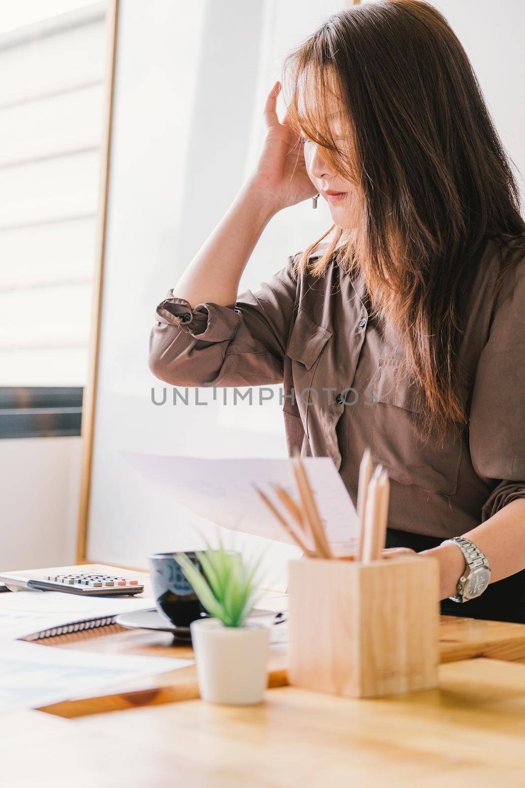 Portrait of business woman working with financial documents and calculator for marketing analysis.