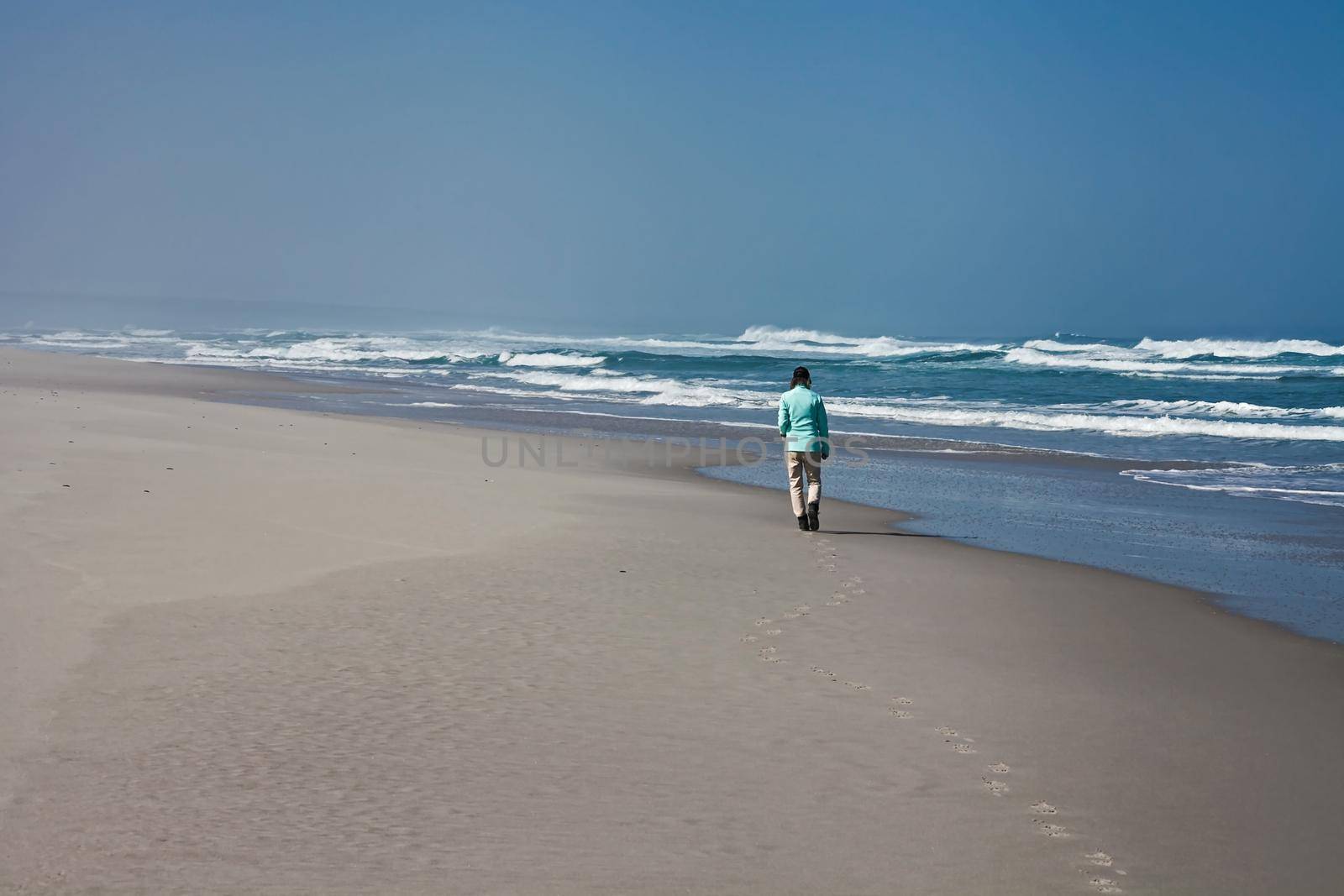 A lone woman walking on a deserted beach