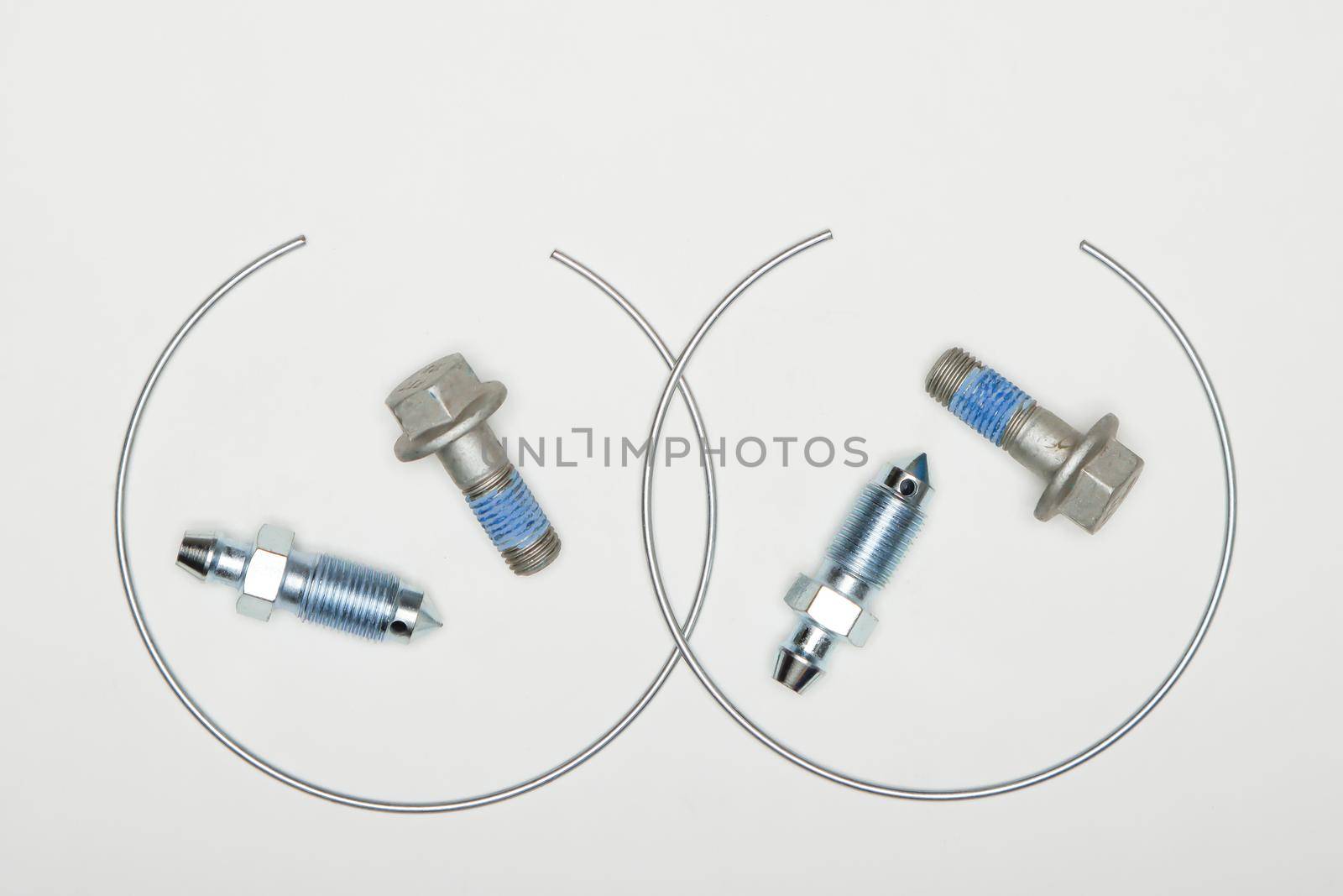 Caliper repair kit, metal retaining rings, union and bolts. Set of spare parts for car brake repair. Details on white background, copy space available. UHD 4K.